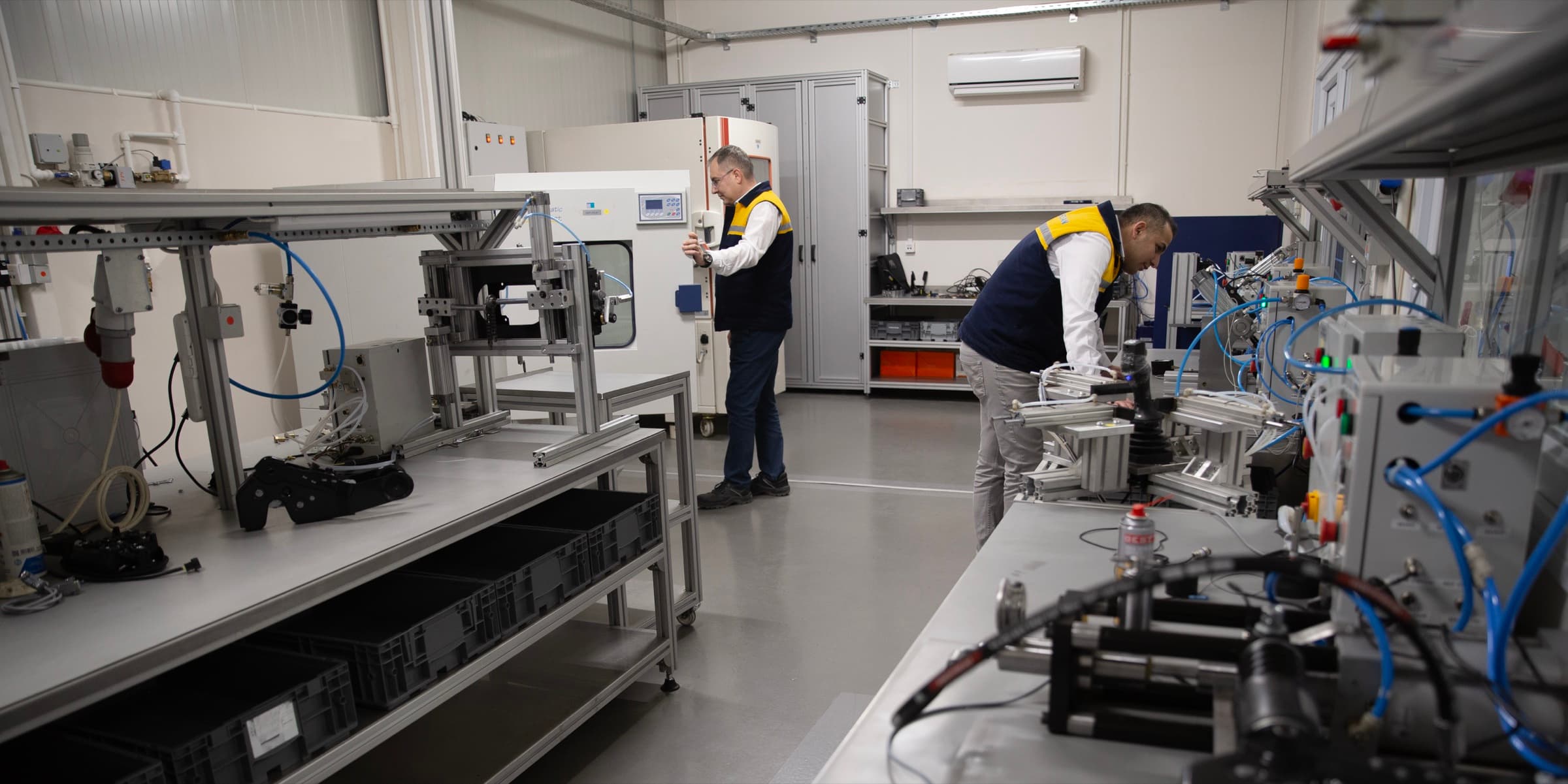 Engineers running joystick endurance tests next to an environmental test chamber in the Makersan R&D laboratory